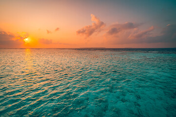 Sunset sky over sea horizon in evening. Colorful clouds orange sunlight, Dusk calm water bay sunrise sky, sun through the clouds. Meditation ocean freedom abstract nature. Tranquil panoramic seascape
