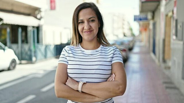 Middle eastern woman smiling confident with crossed arms at street