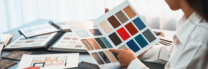 Interior architect designer at workstation table choosing various color samples art tool design...