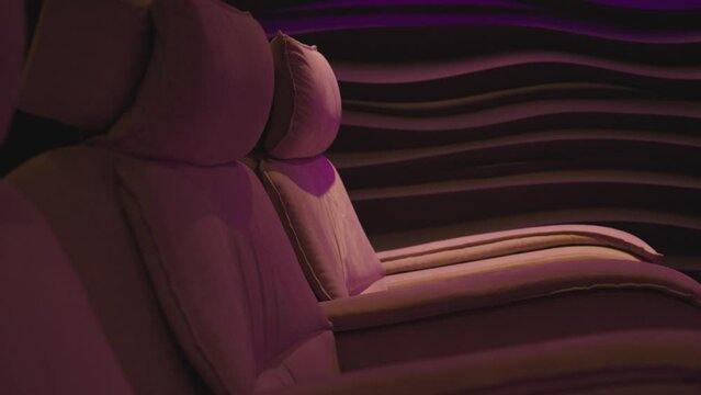 The image depicts plush reclining chairs in a cinema theater. These comfortable seats are designed to provide a luxurious movie-watching experience. 