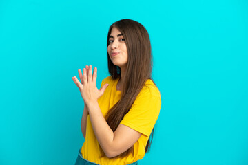 Young caucasian woman isolated on blue background scheming something