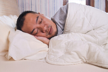 Close up man sleeping on the bed with white blanket