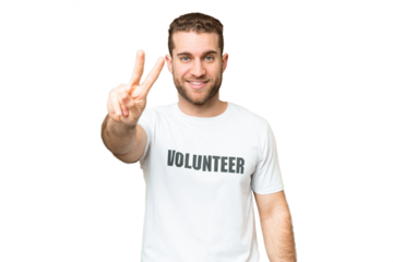 Young volunteer man over isolated chroma key background smiling and showing victory sign
