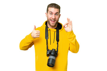 Young photographer man over isolated chroma key background showing ok sign and thumb up gesture