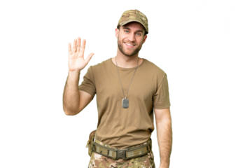 Military with dog tag over isolated chroma key background saluting with hand with happy expression