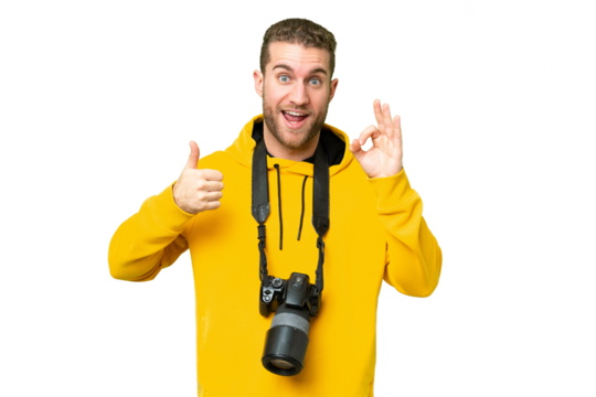 Young photographer man over isolated chroma key background showing ok sign and thumb up gesture