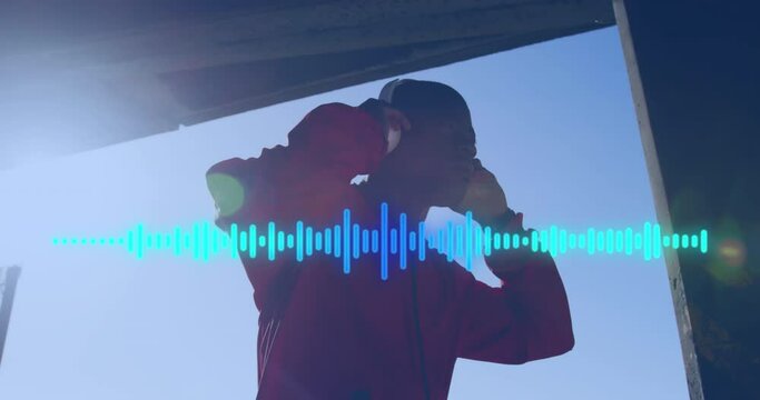 Animation of soundwaves over african american man in headphones exercising outdoors in sun