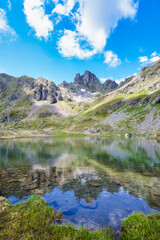 Fototapeta na wymiar Alpine lake with mountains and clouds