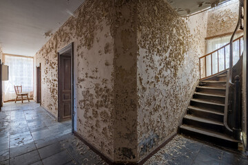 Ein Flur in einem alten Gebäude mit abblätterndem Putz an den Wänden
