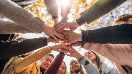 A gathering of young adults clasping their hands in unity - Diverse group of university students joining hands in a stack - The notion of human connection, societal bonds, communal Generative AI - obrazy, fototapety, plakaty