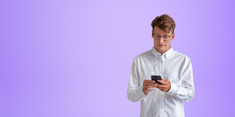 Cheerful young European businessman in white shirt looking at smartphone screen, purple