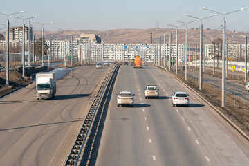Multi-lane road with a dividing strip against the backdrop of the city.
