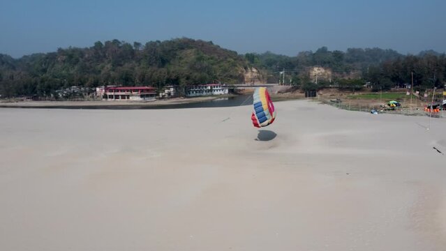hooked flying parachute of parasailing extreme sports on Cox's Bazar sea beach in blue sky background