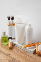 Bath accessories with brushes on table near light wall