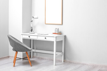 Interior of light room with workplace and armchair