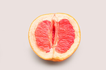Half of grapefruit on light background. Sex concept