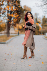 A woman walks outdoors in autumn, enjoys the autumn weather.