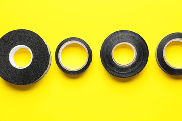 Adhesive tape rolls on yellow background
