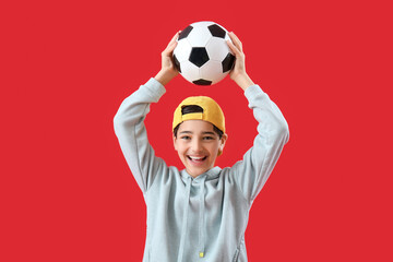 Little boy with soccer ball on red background