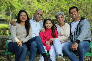 Fototapeta premium Happy Indian family with grandparents enjoying in the greenery