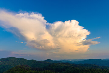 Large clouds  at dusk above the forested mountains, Bijele stijene reserve in Croatia