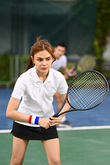 Focused female athlete with a racket waiting to receive ball during match. Sport, training and active life concept