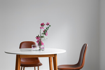 Beautiful ikebana on dining table in light room