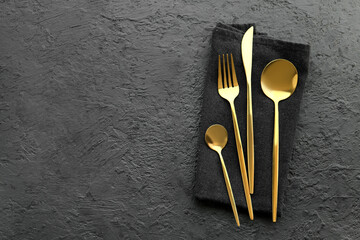 Golden cutlery on black background