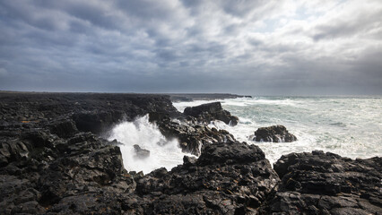 Waves clashing on the black lava rocks of reykjanes coastline in iceland