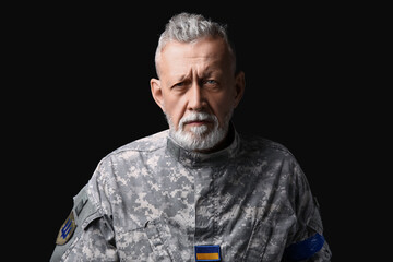Ukrainian soldier on dark background, closeup