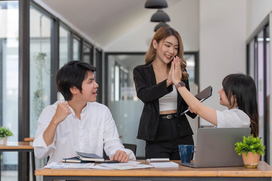 Group meeting of startup company brainstoming about website interface workflow and use laptop to complete the system test success