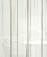 A white clean curtain covers the window in the bedroom see-through the outside.