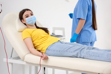 Young woman donating blood in clinic