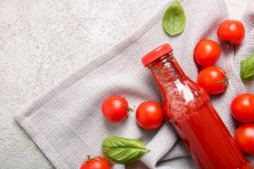 Glass bottle of ketchup and tomatoes on white background