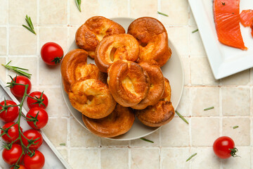 Plate with tasty Yorkshire pudding on light tile background