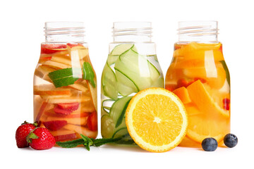 Bottles of infused water with different sliced fruits on white background