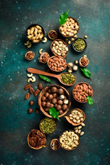 Nuts mix in a wooden plate. Top view. On a dark background.