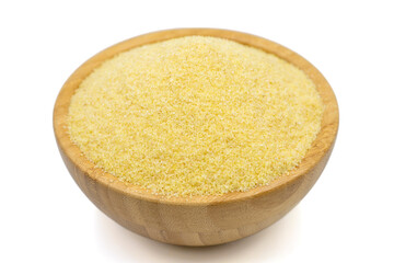Dry organic semolina flour isolated on white background. Uncooked organic semolina in wooden bowl. Close up