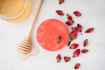 Handmade solid shampoo with honey and dry flowers on light background