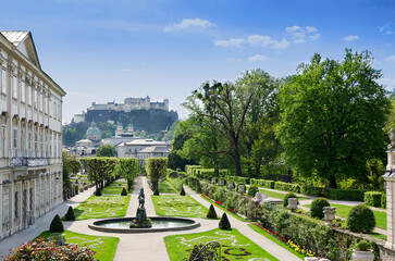 Naklejka premium Salzburg city in Austria, historic center with Baroque Mirabell Palace and Garden, and with Hohensalzburg Fortress in the distance, one of the largest fortress in Europe, dating from the 11th century.