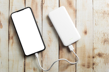 Phone and power bank, on a wooden background