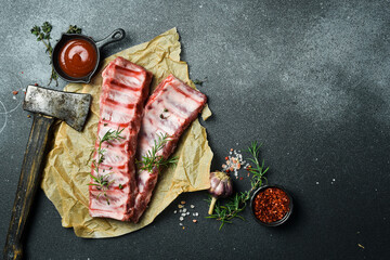 Fresh raw pork ribs with rosemary and spices. Ready to cook. Top view. Free space for text.