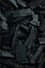 Black charcoal background. Charcoal. Vertical photo. Top view. Space for text.