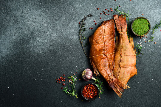 Smoked fish red sea bass. Sea bass closeup. Delicious seafood for proper nutrition. On a black background. Free space for the recipe.