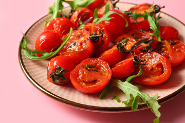 Plate with tasty grilled tomatoes and arugula on pink background
