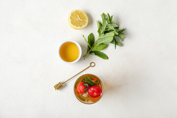 Glass of ice tea with strawberry and mint on white background