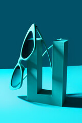 Podium with stylish sunglasses on blue background