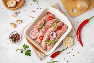 Fototapeta na wymiar Baking dish with raw homemade sausages on light background