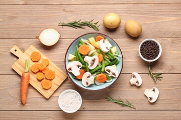 Bowl with fresh vegetables on wooden background