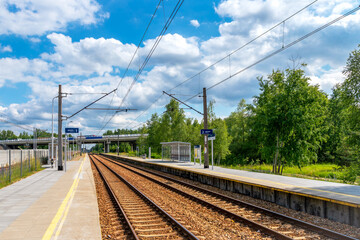 A small railway station. Car bridge in the background Railway and car transport. Sunny day